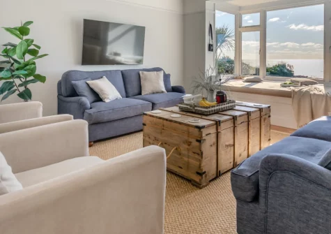 Dolphins, Downderry is a stunning five-bedroom beach house set on the cliff edge with private beach access, boasting spectacular sea views, contemporary coastal interiors, a level garden with a games room, and parking for up to ten cars.