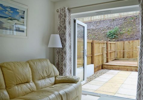 The living area & decked patio at Driftwood, Goodrington