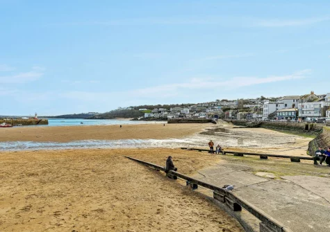 As the tide goes out, a soft sandy beach is revealed in front of the shops, pubs, cafes & galleries that line the harbour wall