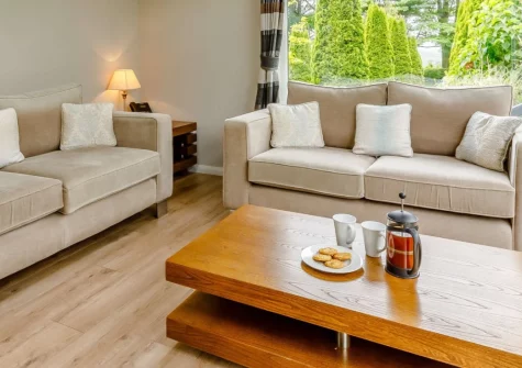 Exmoor View at Kentisbury Grange is a luxurious two-bedroom lodge set within historic manor house grounds, featuring a private hot tub, contemporary interiors, and a restaurant onsite, perfectly placed between Exmoor's trails & North Devon's beaches.