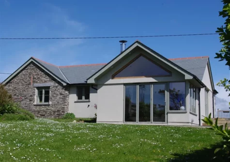 The enclosed garden, bordered by mature shrubs, at Farmlands, Porthcothan