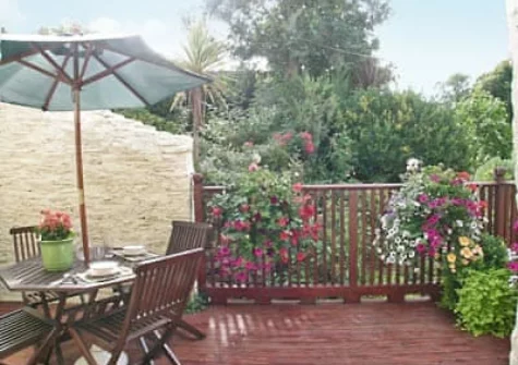 The decked balcony, barbecue & alfresco dining area at Fordbrook Cottage, Brixton