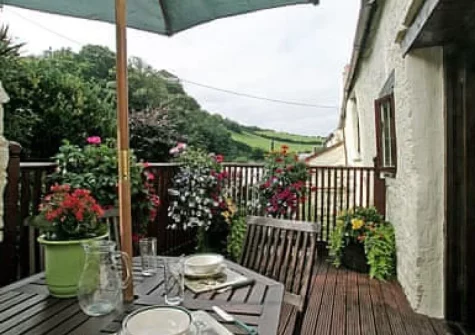 The decked balcony, barbecue & alfresco dining area at Fordbrook Cottage, Brixton