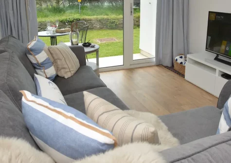 Fourteen Mawgan Porth, Mawgan Porth is an elegant ground-floor apartment with countryside views, private patio, and access to shared pool and tennis courts. Just minutes from golden sands and village amenities for an unforgettable Cornish break.