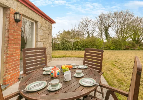 The patio, alfresco dining area & large lawned enclosed garden at Foxglove Cottage at Gadles Farm, Laity Moor