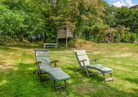 The garden with treehouse & outdoor seating at Fox's Folly, North Tamerton