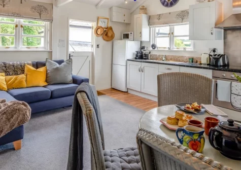 Fox's Folly, North Tamerton is a charming detached cabin set in peaceful countryside near Bude, featuring vaulted beamed ceilings, country views from a covered deck, resident farmyard animals, and starlit skies above North Cornwall's rural lanes.