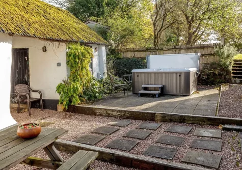 The patio, alfresco dining area & hot tub at Fursdon Farmhouse, Iddesleigh