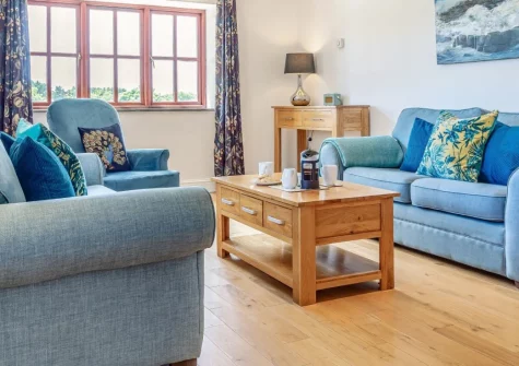 Geevor, Germoe is a beautifully converted barn nestled in peaceful countryside near Praa Sands, featuring exposed beams, contemporary interiors, three en-suite bedrooms, and an enclosed garden, perfect for families seeking traditional seaside breaks.