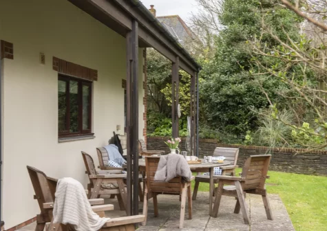 The patio, barbecue, alfresco dining area & wraparound garden at Godolphin at Roserrow, Polzeath