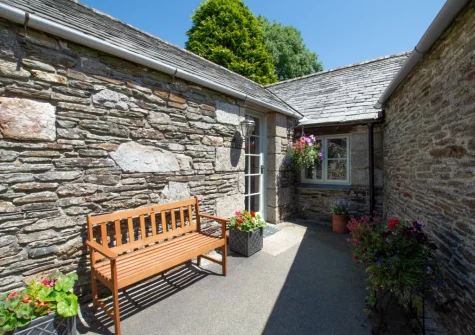The rear patio & outdoor sitting area, sheltered by the barn walls, at Goosehill at Penrose Burden, St Breward