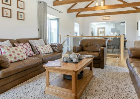 Grampys Barn, Bray Shop is a stunning converted barn on the edge of Bodmin Moor, featuring spacious reverse-level living with countryside views, three elegant bedrooms, and an enclosed patio with fire pit, perfectly placed between Cornwall's coasts.
