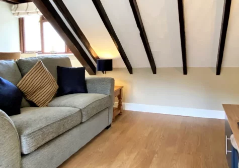 Granary Cottage at Heddon Valley Mill, Killington is a romantic woodland retreat deep in Exmoor National Park, featuring exposed beams, contemporary styling, a Juliette balcony overlooking the river, and a private deck surrounded by ancient forest.