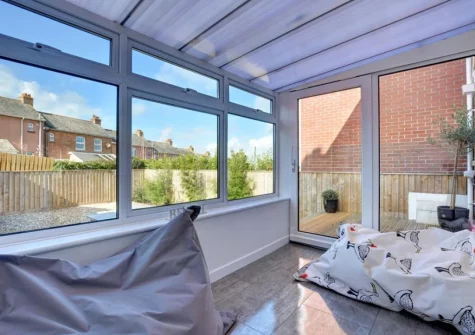 The conservatory leads out to the decked patio alfresco dining area & garden at Gull Rock, Padstow