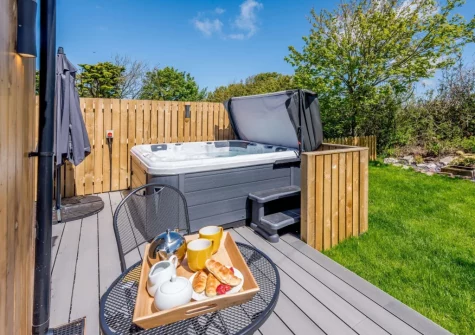The decked patio, outdoor sitting area, hot tub & garden at Hartnolls Lodge, Woolacombe