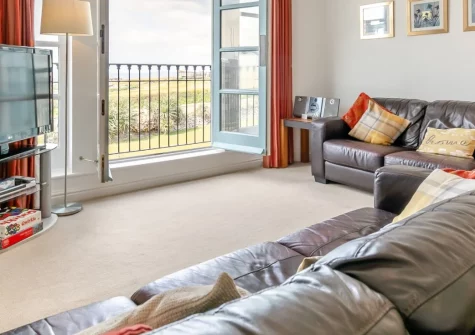 Headland House, Newquay is a spacious three-bedroom retreat boasting breathtaking ocean views over Fistral Beach, featuring a sunny south-facing garden, contemporary interiors, and coastal path access, perfect for surfers and beach lovers.