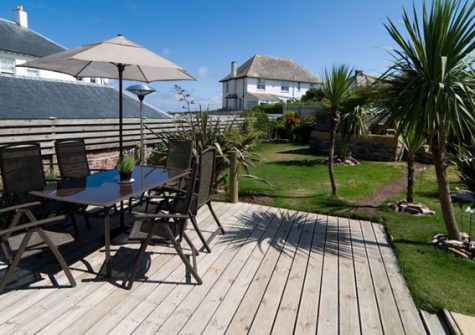The spacious garden features a decked area with patio furniture