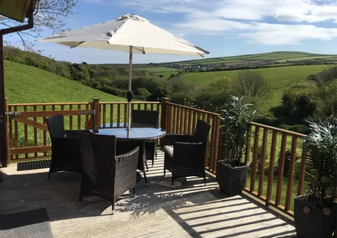 The decked terrace & alfresco dining area at Hideaway Lodge, Bossiney