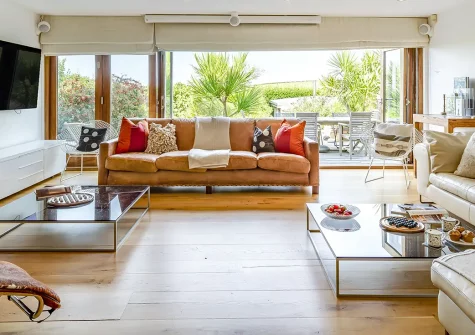 Higher Close, Mawgan Porth is a spacious beachside home with four en-suite bedrooms, home cinema, and mature gardens with pizza oven. Steps from the beach, it's ideal for families and couples seeking seaside charm and sophisticated coastal comfort.