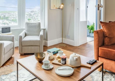 Hillhead, Perranporth is a stylish ground-floor apartment with sweeping coastal views across this vibrant village, featuring contemporary interiors, a sun-trap terrace, and direct access to three miles of golden sand and dramatic coastal paths.