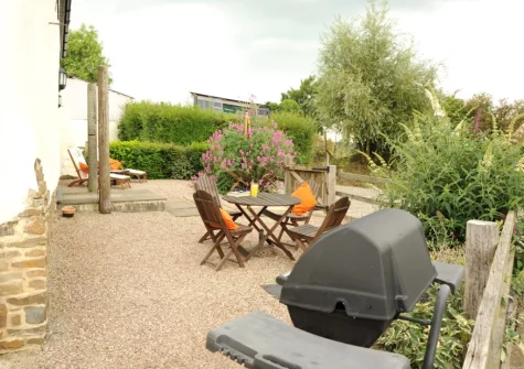 The enclosed gravelled patio, barbecue & alfresco dining area at Holder's Barn, Monkokehampton