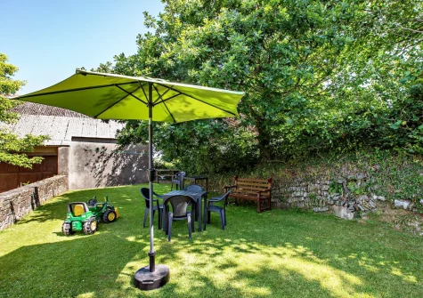 The enclosed lawned garden, barbecue & alfresco dining area at Honeysuckle Cottage, Frithelstock
