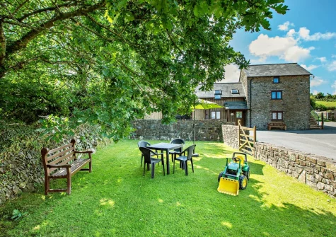 The enclosed lawned garden, barbecue & alfresco dining area at Honeysuckle Cottage, Frithelstock