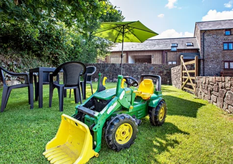 The enclosed lawned garden, barbecue & alfresco dining area at Honeysuckle Cottage, Frithelstock