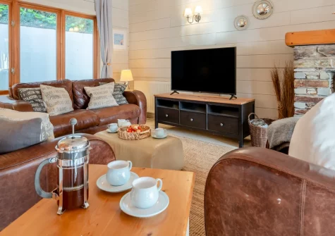 Honeywood, Little Petherick is a stunning Canadian-style log cabin in peaceful countryside, featuring spacious dual lounges, flexible sleeping for six, expansive outdoor decking with valley views, and easy access to Padstow and Cornwall's coast.