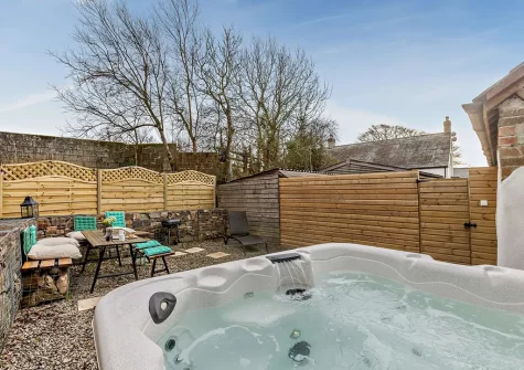 The courtyard, alfresco dining area & hot tub at Horseshoe Cottage, Ashwater