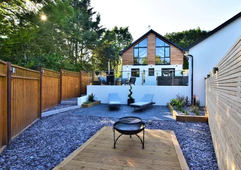 The lower patio with sun loungers & firepit at Hyford Wood, Bideford