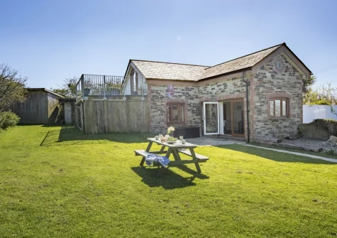 The alfresco dining area & large lawned garden at Ivy Chimney Cottage, Wheal Rose