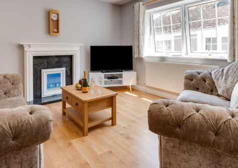 Jackdaws, Fowey is a bright two-bedroom apartment on the popular esplanade in the heart of this historic estuary town, featuring pretty river views across the rooftops, modern interiors, and immediate access to waterfront dining and coastal walks.