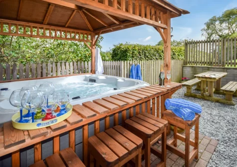 The gravel garden, barbecue, alfresco dining area & hot tub at Jasmine Cottage at Little Roseveth, Tregavethan