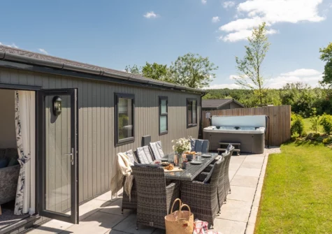 The patio, alfresco dining area, hot tub & garden at Juniper Lodge, 28 Roadford Lake Lodges, Broadwoodwidger