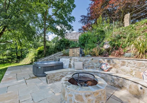The lower patio, outdoor sitting area, firepit & hot tub at Kelly Mill Cottage, Lifton