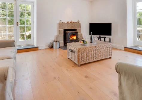 Kemyel Mill, Lamorna is a beautifully converted three-bedroom mill house set in peaceful Cornish countryside, featuring original stone walls, contemporary interiors, and a spectacular half-acre garden with its own stream and rotating summerhouse.