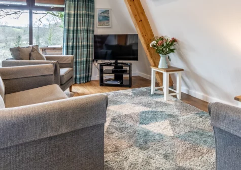 Lakeside Haven, Kilkhampton is an attractive Scandinavian lodge set within 17 acres of peaceful Cornish countryside, featuring a private lakeside patio, on-site pool and spa facilities, and easy access to North Cornwall's stunning coastline.