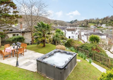 The patio, alfresco dining area, hot tub & rear garden at Lerryn Cottage, Lostwithiel