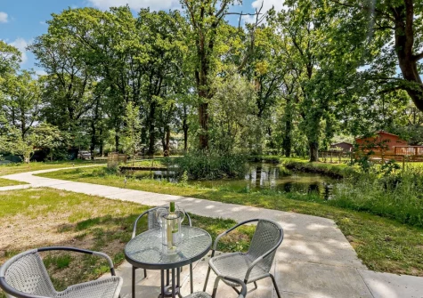 The patio & alfresco dining area, with views over the lake, at Little Cedar at Meldon Lodge Park, Meldon