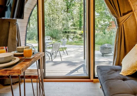 Little Cedar at Meldon Lodge Park, Meldon is a contemporary pod retreat on Dartmoor's edge, featuring a private hot tub with lake views, stylish open-plan living with mood lighting, and direct access to moorland walks and castle ruins.