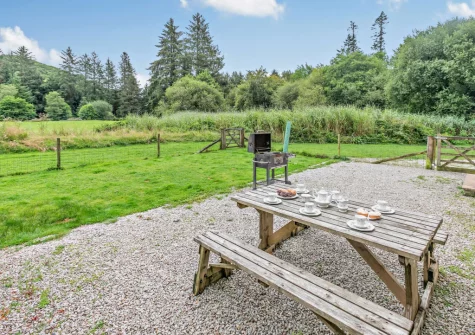 The patio, barbecue, alfresco dining area & enclosed gaden at Loveny Cottage, Two Waters Foot