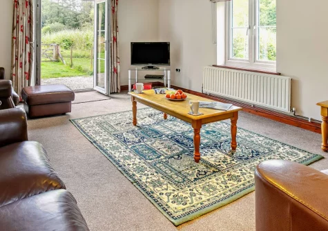 Loveny Cottage, Two Waters Foot is a peaceful three-bedroom cottage surrounded by acres of private woodland, tranquil lakes and rivers, featuring an enclosed garden, shared games room, and countryside location perfect for exploring both coasts.