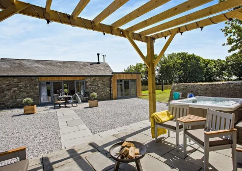 The patio, outdoor sitting area & hot tub at Lutsford Farm Barn, Bursdon