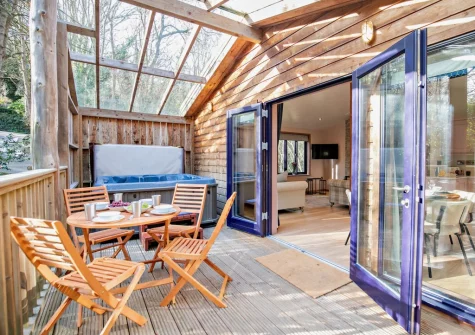 The glass-covered enclosed terrace, alfresco dining area & hot tub at Margot at Rosehill Lodges, Porthtowan