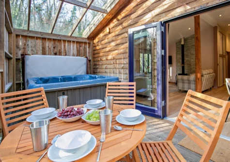The glass-covered enclosed terrace, alfresco dining area & hot tub at Margot at Rosehill Lodges, Porthtowan