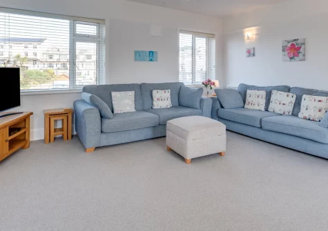 Marnie's View, Sidmouth is an inviting first-floor seafront apartment capturing exceptional Lyme Bay vistas, featuring sea-view bedrooms, bay window dining, and direct beach access just twenty metres from your door in charming Regency Sidmouth.