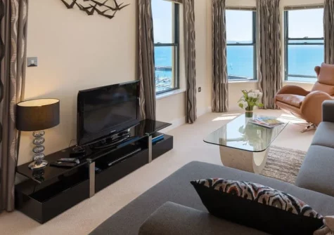 Masts A8, Torquay is a stunning two-bedroom first-floor apartment boasting panoramic views across Torbay and Berry Head from a spacious balcony, contemporary interiors with underfloor heating, and just a five-minute stroll to Torre Abbey Sands.