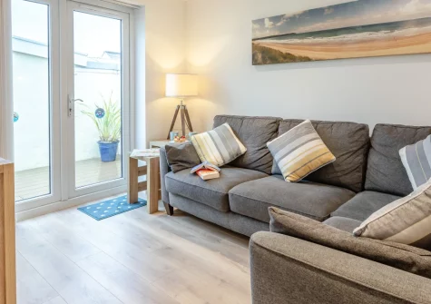 Millrock Cottage, Woolacombe is a beautiful two-bedroom seaside retreat in the heart of the village, just 200 metres from award-winning sands, featuring a sun-drenched decked patio, contemporary nautical interiors, & storage for your beach gear.