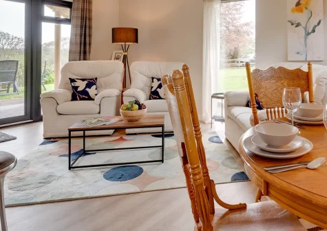 Mimosa, Polsue Gardens, Tresillian is a stylish wooden bungalow in Cornwall's countryside. Enjoy industrial-chic interiors, French doors to gardens, and access to Truro's historic cathedral, beautiful coastlines, and family attractions nearby.